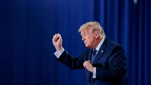 Donald Trump u tamnoplavom odelu ispred plave pozadine