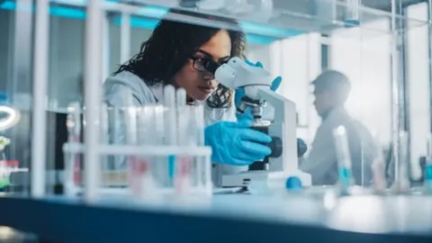 Istraživačica u laboratoriju promatra uzorke pomoću mikroskopa