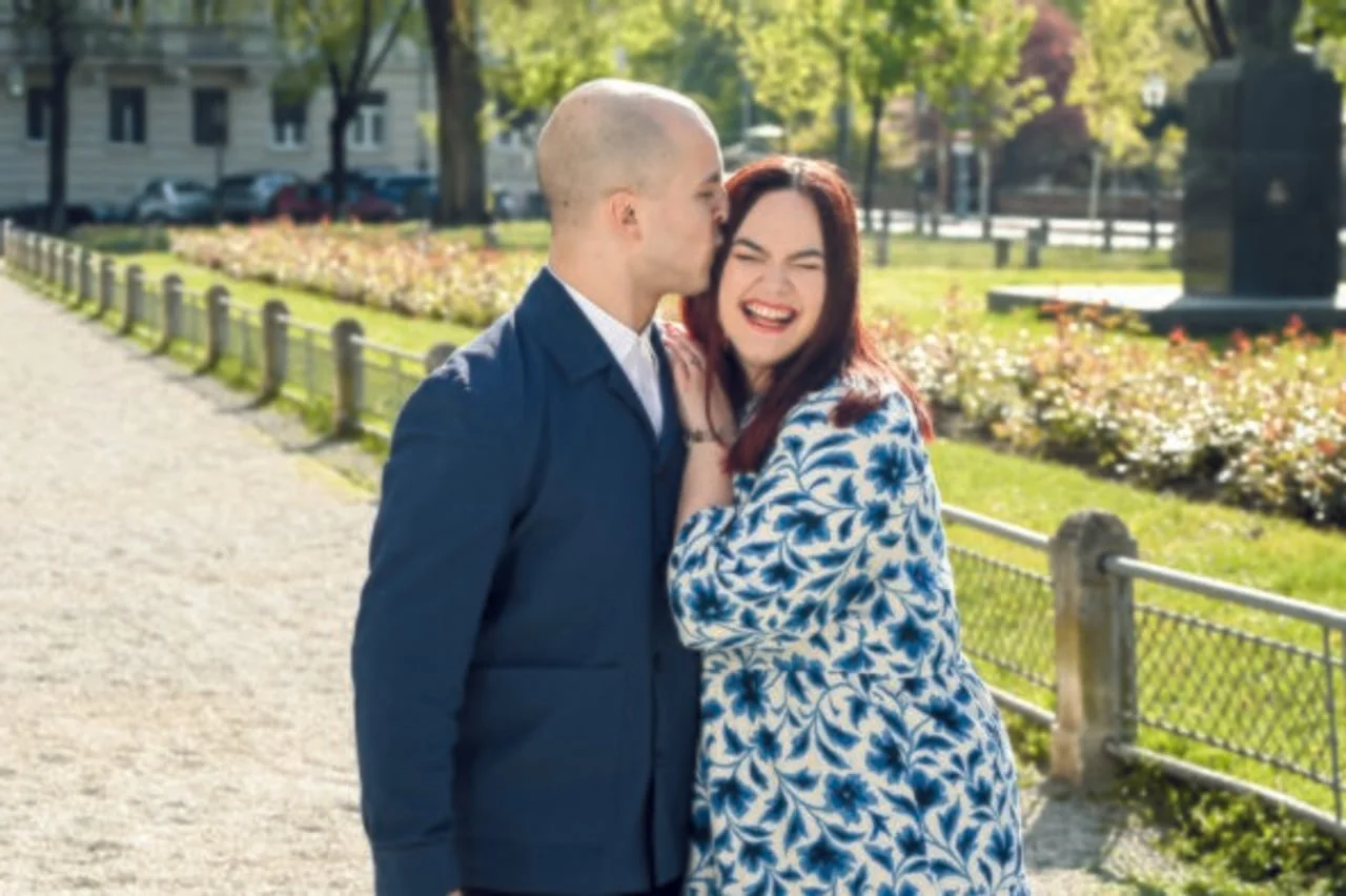 Muškarac poljubljujući ženu u obraz na sunčanoj stazi u parku