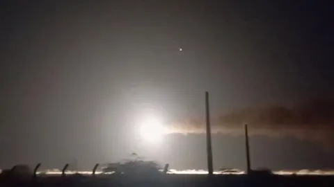 Noćna snimka eksplozije s jakom svjetlošću i dimom na horizontu