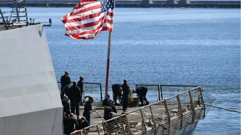 Američka zastava i mornari na palubi ratnog broda u plavim vodama