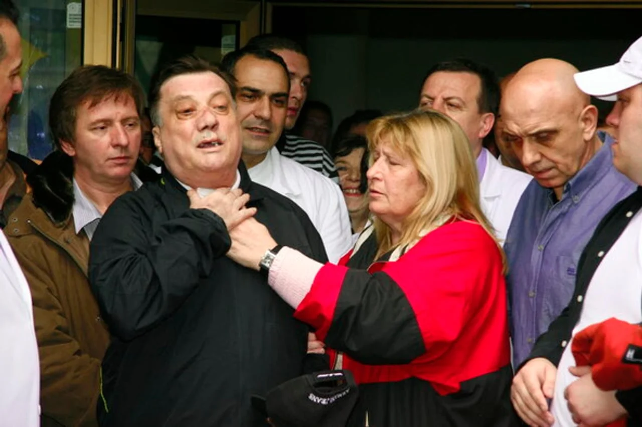 Sejda Bešlić u crvenoj jakni stoji uz supruga Halida u mnoštvu ljudi