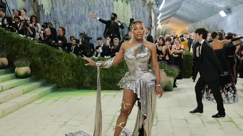Serena Williams u srebrnoj haljini na crvenom tepihu s fotografima u pozadini