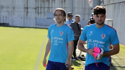 Luka Modrić i suigrač u plavim trening-majicama na nogometnom terenu