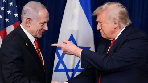 Donald Trump i Benjamin Netanyahu u odelima ispred zastava SAD-a i Izraela