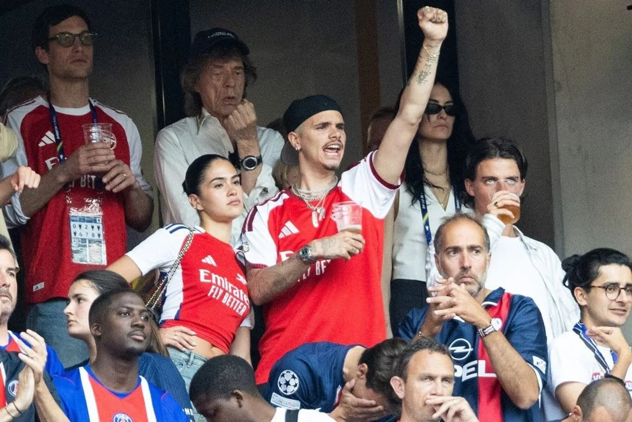 Young couple in red sports jerseys cheering at a stadium