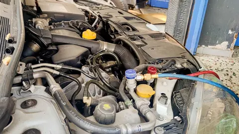 Detaljan prikaz motora automobila s priključenim servisnim crijevima
