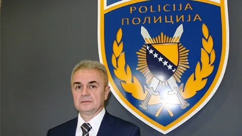 Muškarac u odjeću u službenom portretu pored grba policije