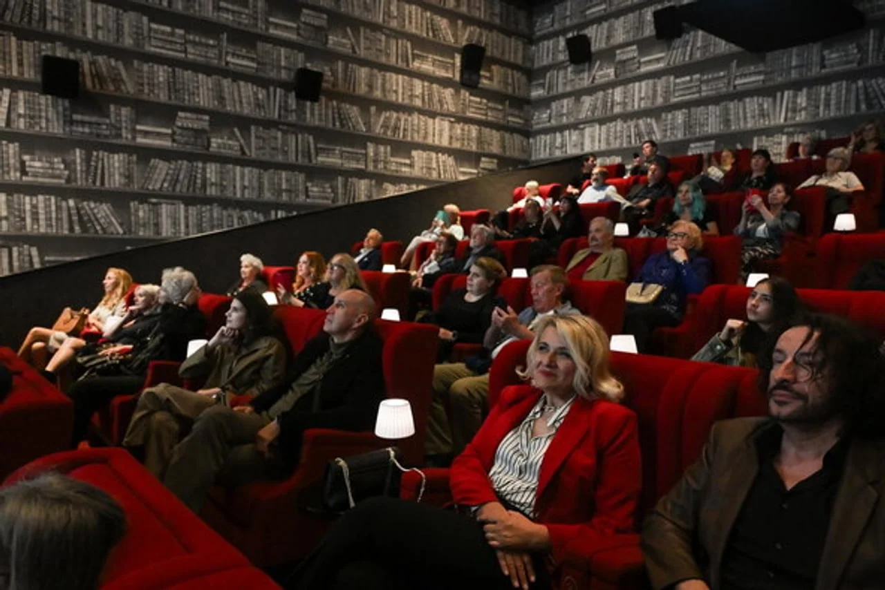 Publika u kino dvorani s crvenim sjedalima