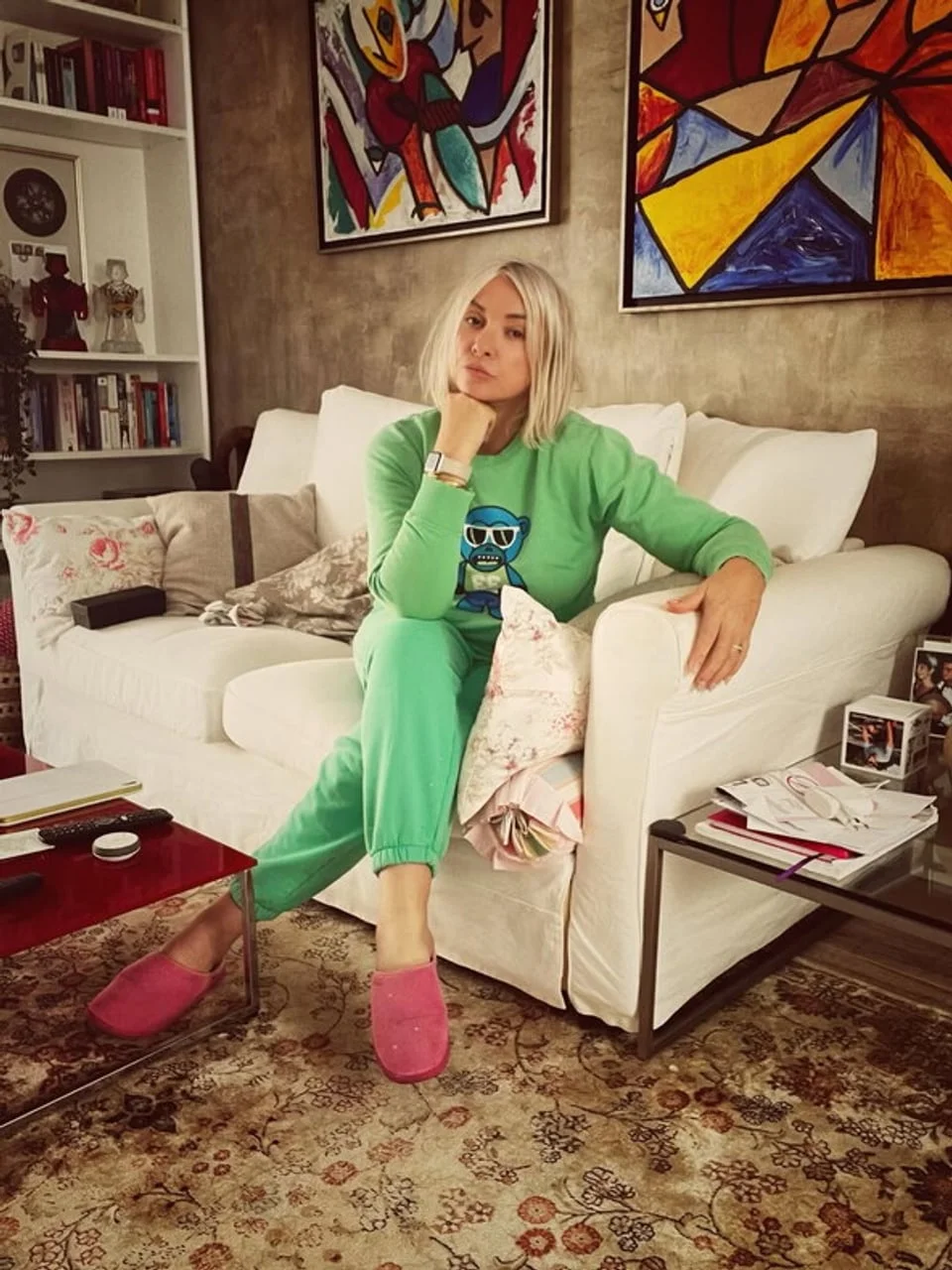 Žena u zelenom donjem rubljy s plavim natrtkom na kauču