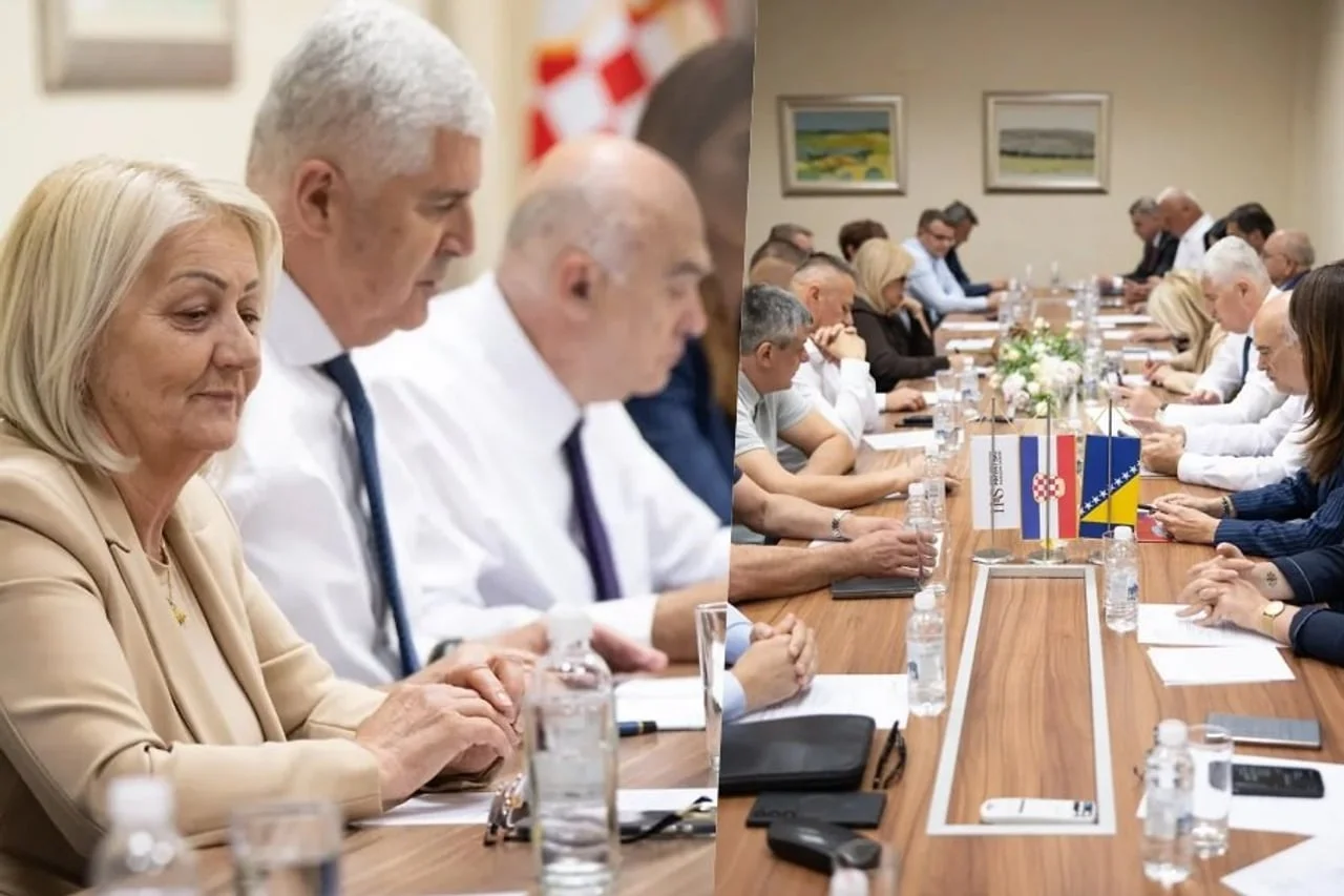 Grupa ljudi u poslovnim odjećama sjedi za dugačkim stolom