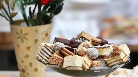 Raznovrsni komadi slojevitih kolača i praline u staklenoj zdjeli