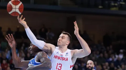 Košarkaš Ivan Vraneš u bijelom dresu Hrvatske s brojem 13 u akciji na terenu