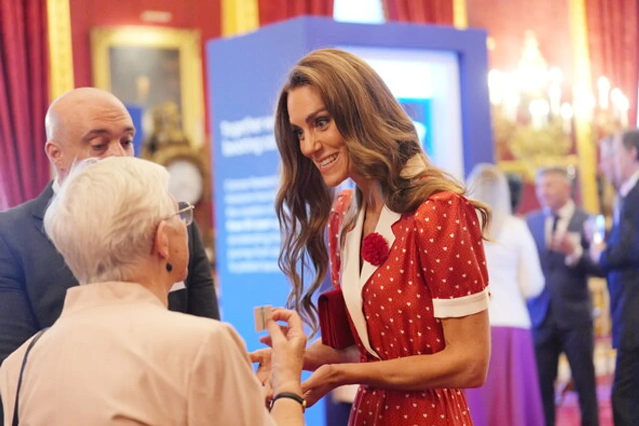 Princeza Kate Middleton razgovara s starijom osobom u elegantnoj prostoriji