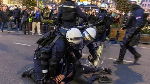 Policajci u punoj opremi i s kacigama pritvaraju osobu na cesti