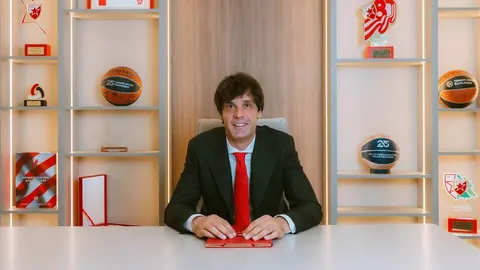 Miloš Teodosić u crnom odijelu i crvenoj kravati sjedi za stolom