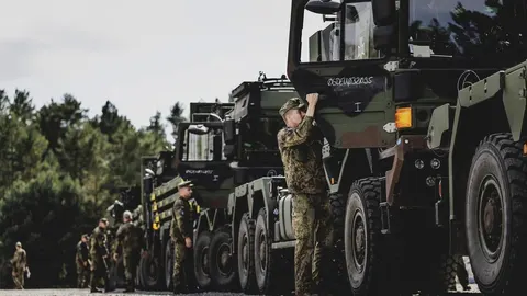 Red vojnih vozila i vojnika u kamuflažnim uniformama na otvorenom