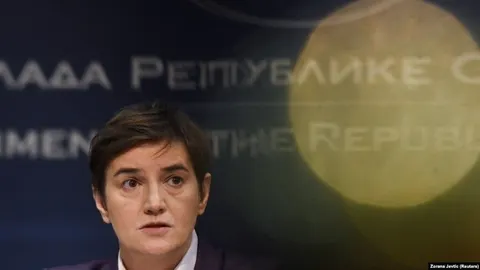 Portret Ane Brnabić ispred plave pozadine s natpisom Vlada Republike Srbije
