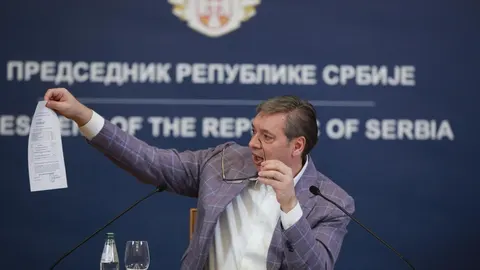 Aleksandar Vučić drži papir ispred natpisa Predsjednik Republike Srbije