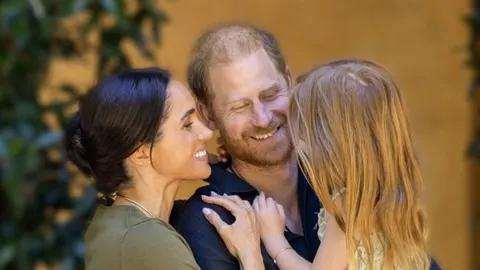 Meghan Markle, princ Harry i njihova kćer Lilibet nasmijani u zagrljaju