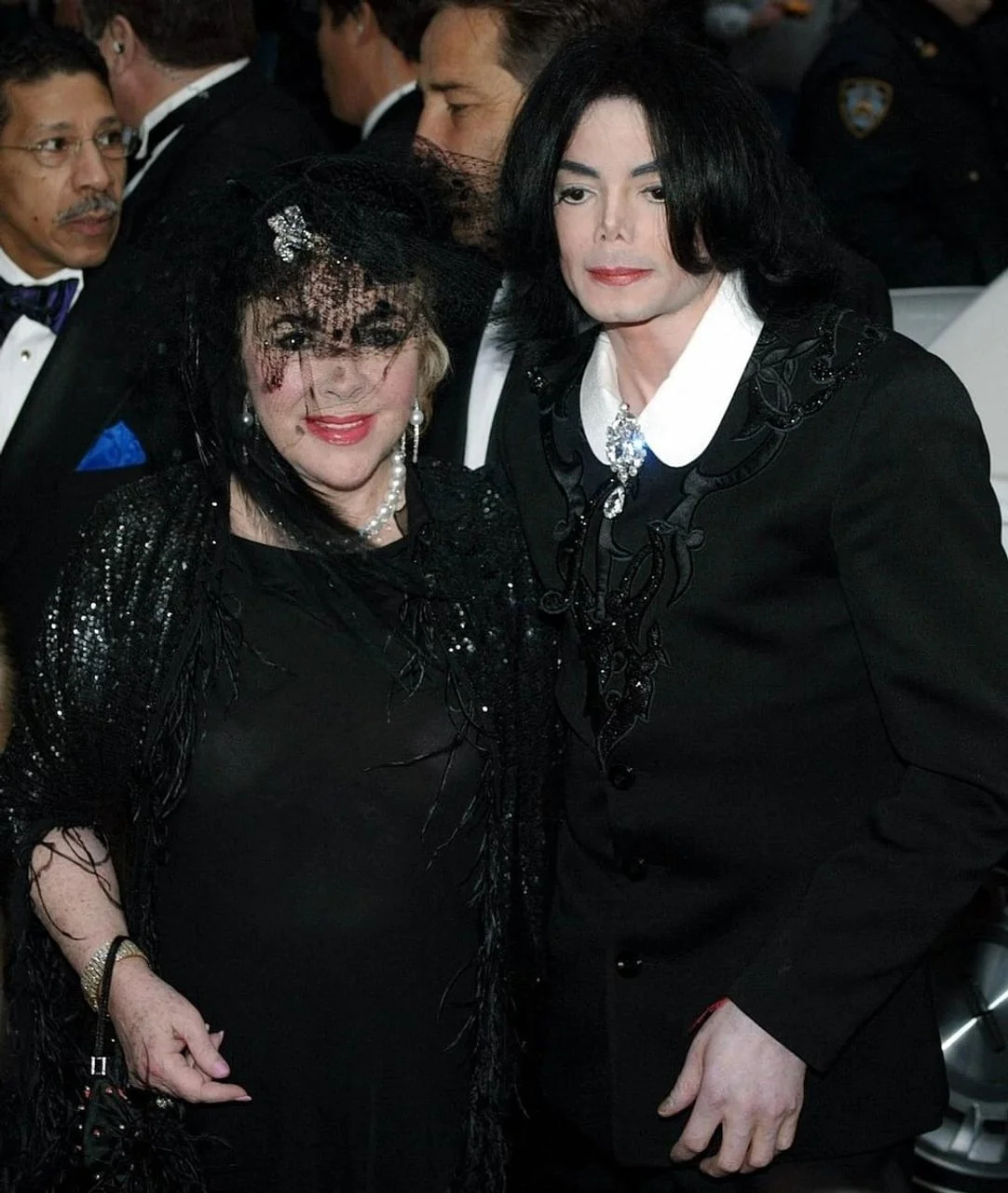 Michael Jackson u crnom odelu pored žene u crnoj mrežci