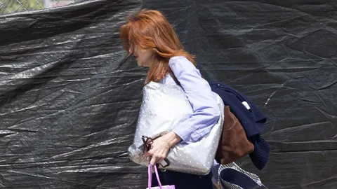 Glumica Marcia Cross u profilu s velikom srebrnom torbom