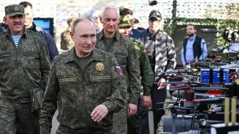Vladimir Putin u vojnoj uniformi hoda pored reda dronova