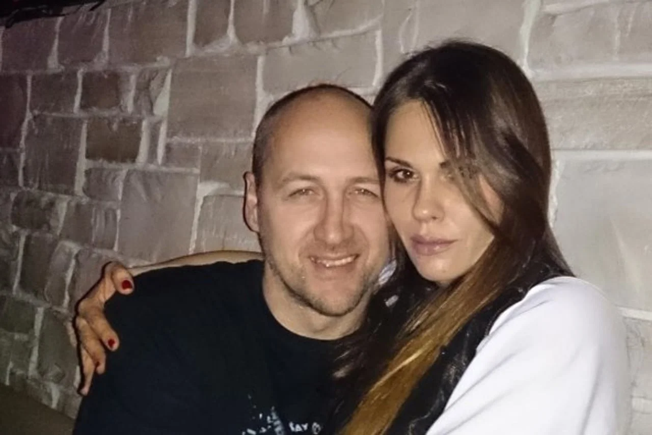 Viktorija Rađa i muškarac koji se smije ispred kamenog zida