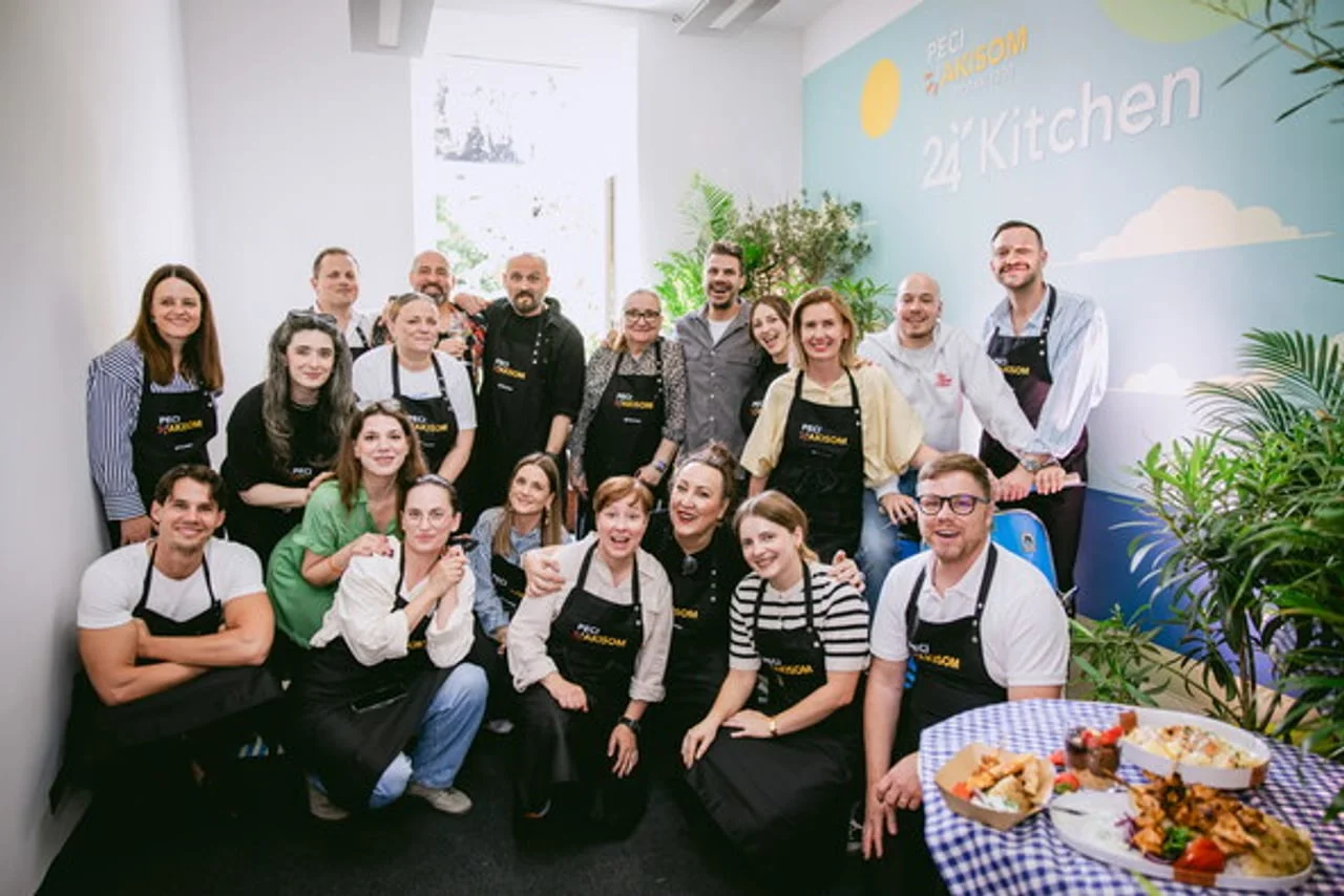 Grupa ljudi u kuhinjskim pregačama pozira za zajedničku fotografiju