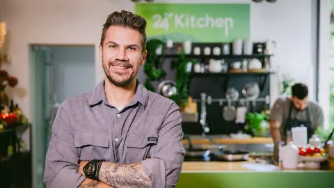 Portret nasmijanog chefa Akisa Petretzikisa u modernoj kuhinji