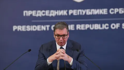 Aleksandar Vučić u tamnom odelu i naočalama govori za govornikom