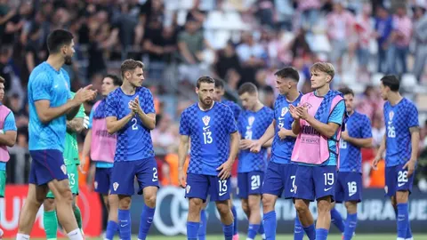 Nogometni igrači Hrvatske reprezentacije u plavim kockastim dresovima na terenu
