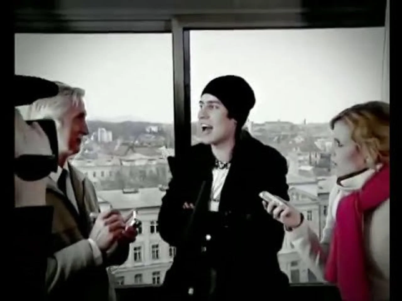 Kadar iz videa s mladim muškarcem u crnoj kapi i dvije osobe