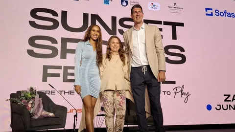 Judit Polgar stoji na pozornici između muškarca i žene ispred natpisa Sunset Festival