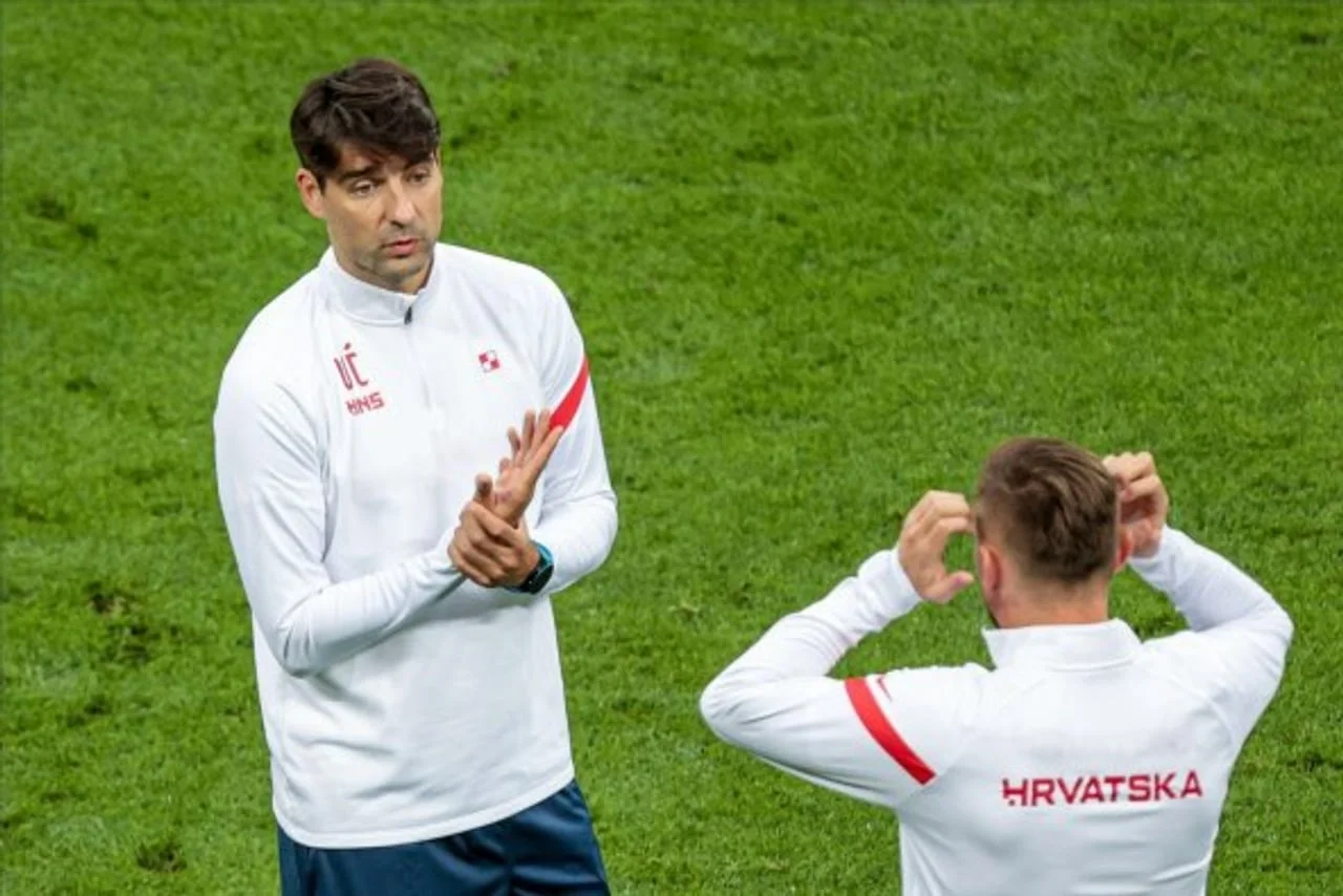 Vedran Ćorluka u bijeloj HNS training majici razgovara s igračem