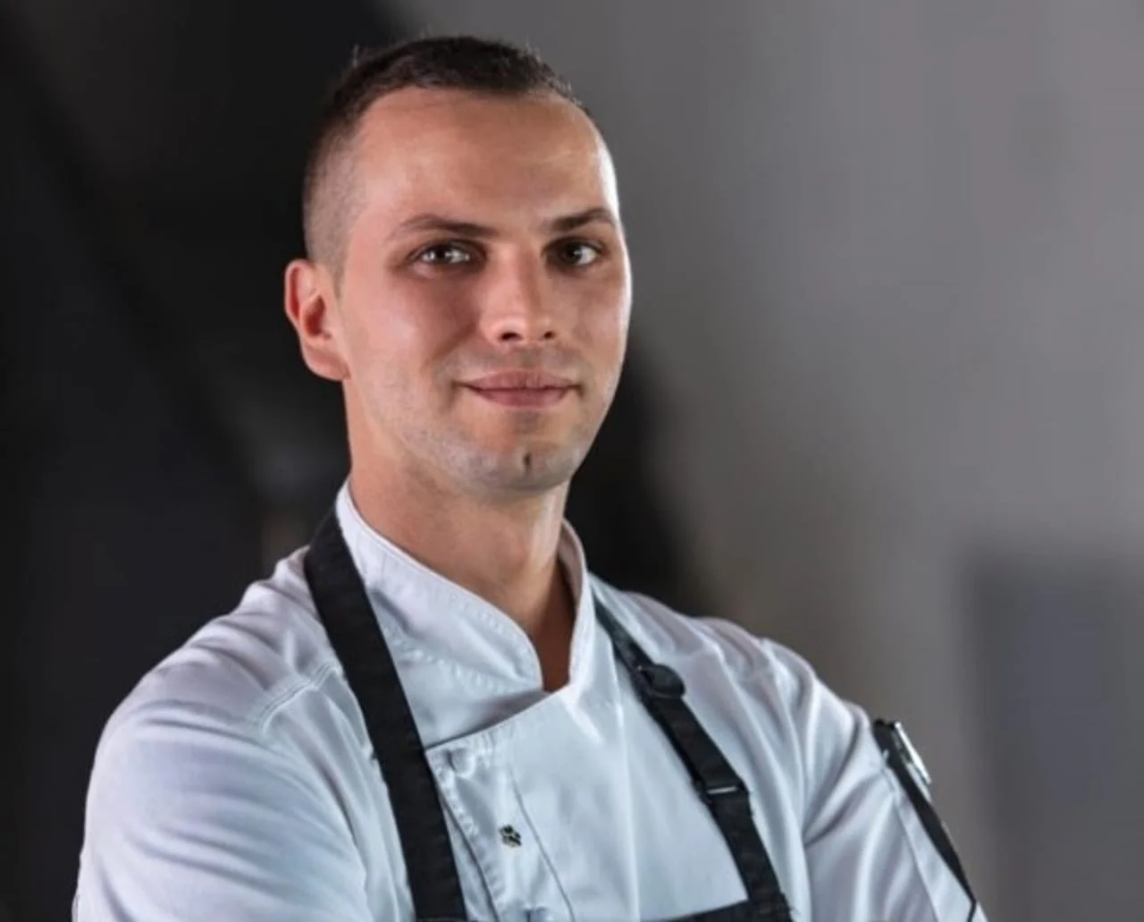 Blizu portret muškarca u bijeloj kuhinjskoj uniformi