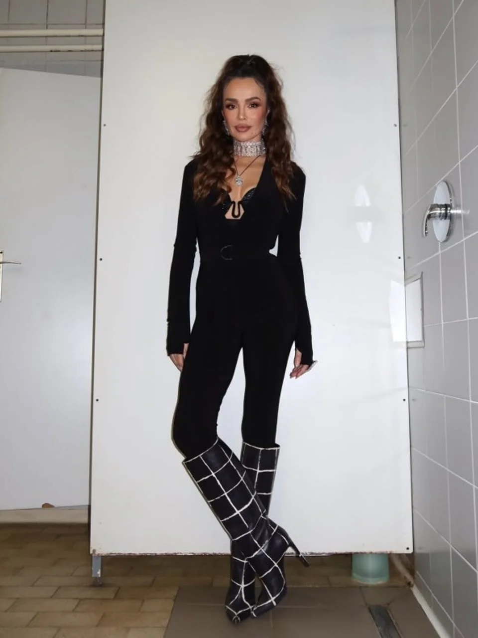 Severina u crnom kombinezonu i visokim crnim čizmama s bijelim kvadratima