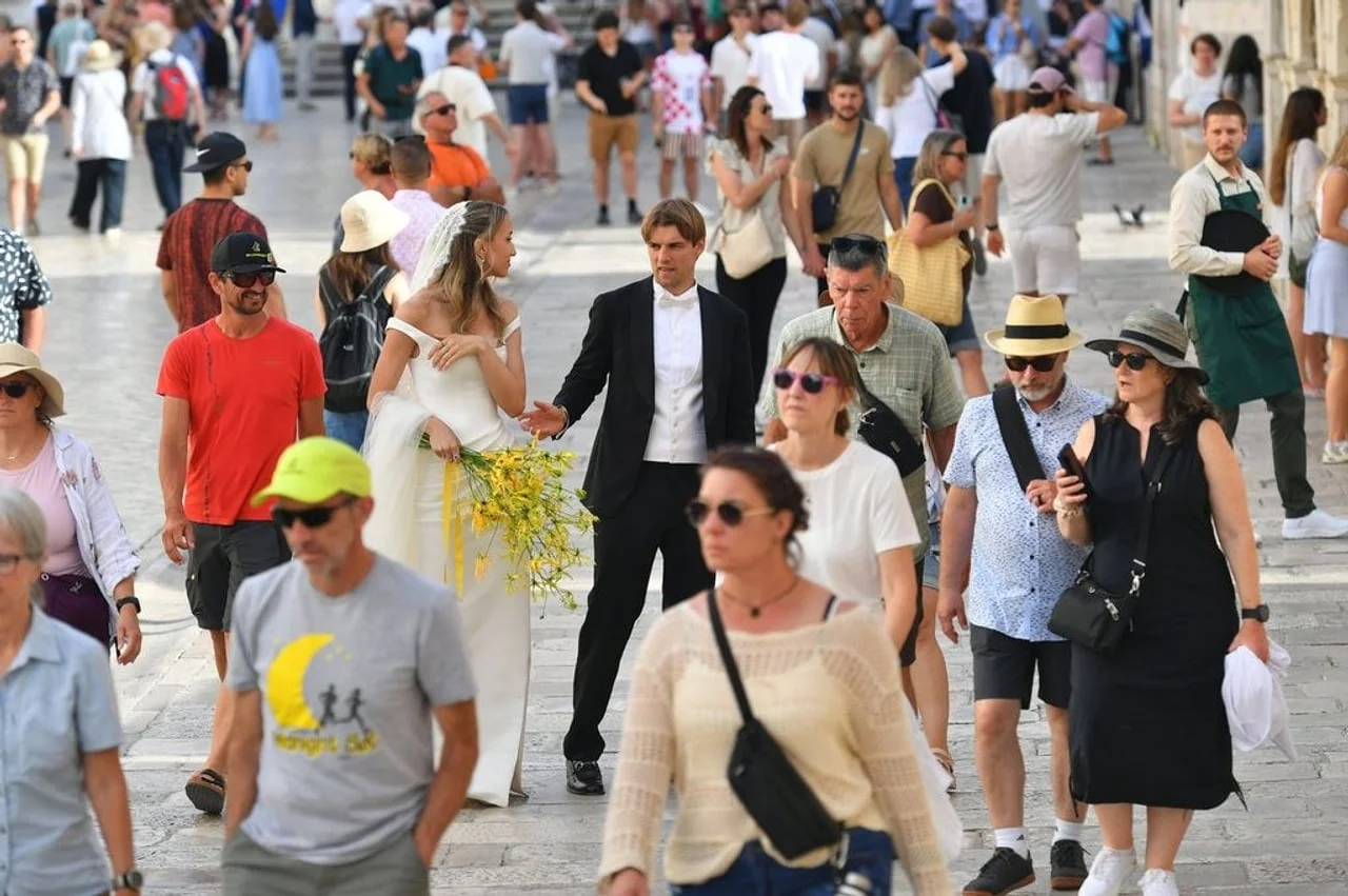 Vjenčani par u prolasku kroz gužvu ljudi na trgu