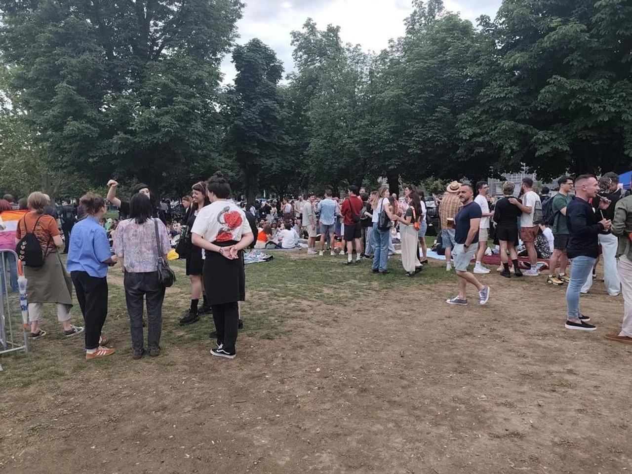 Okupljanje ljudi na zelenoj površini s drvima u pozadini
