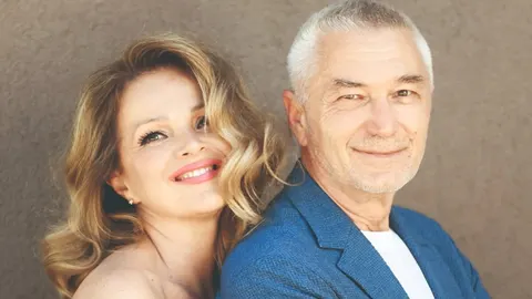 Portret nasmijane žene i sijedog muškarca u plavom saku