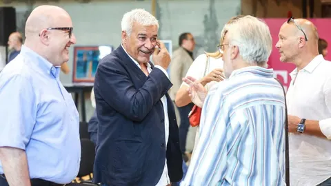 Grupa muškaraca u razgovoru na društvenom događaju
