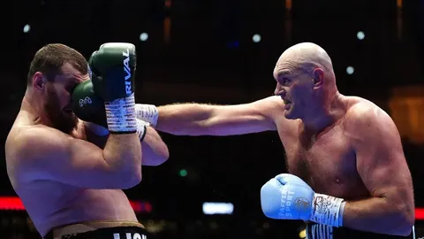 Tyson Fury udara boksačku rukavicu u protivnika tijekom meča