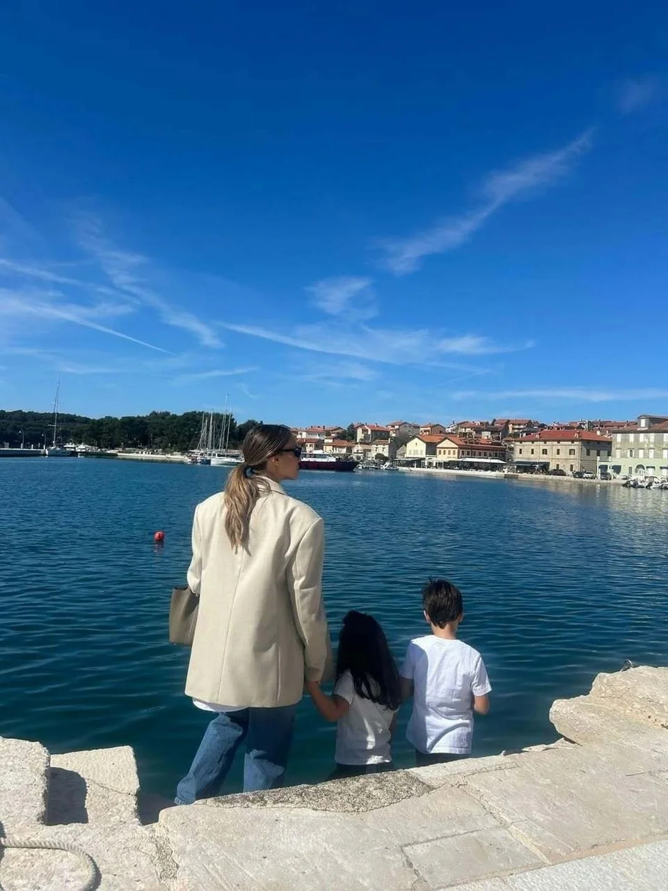 Franka i djeca gledaju prema obali grada uz more