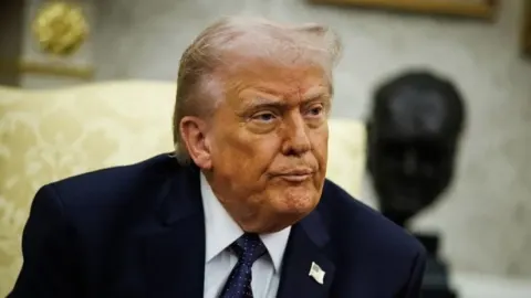 Donald Trump u Ovalnom uredu sjedi ispred biste Winstona Churchilla.