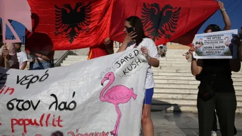 Protestnici s albanskim zastavama i transparentom s crtežom flaminga