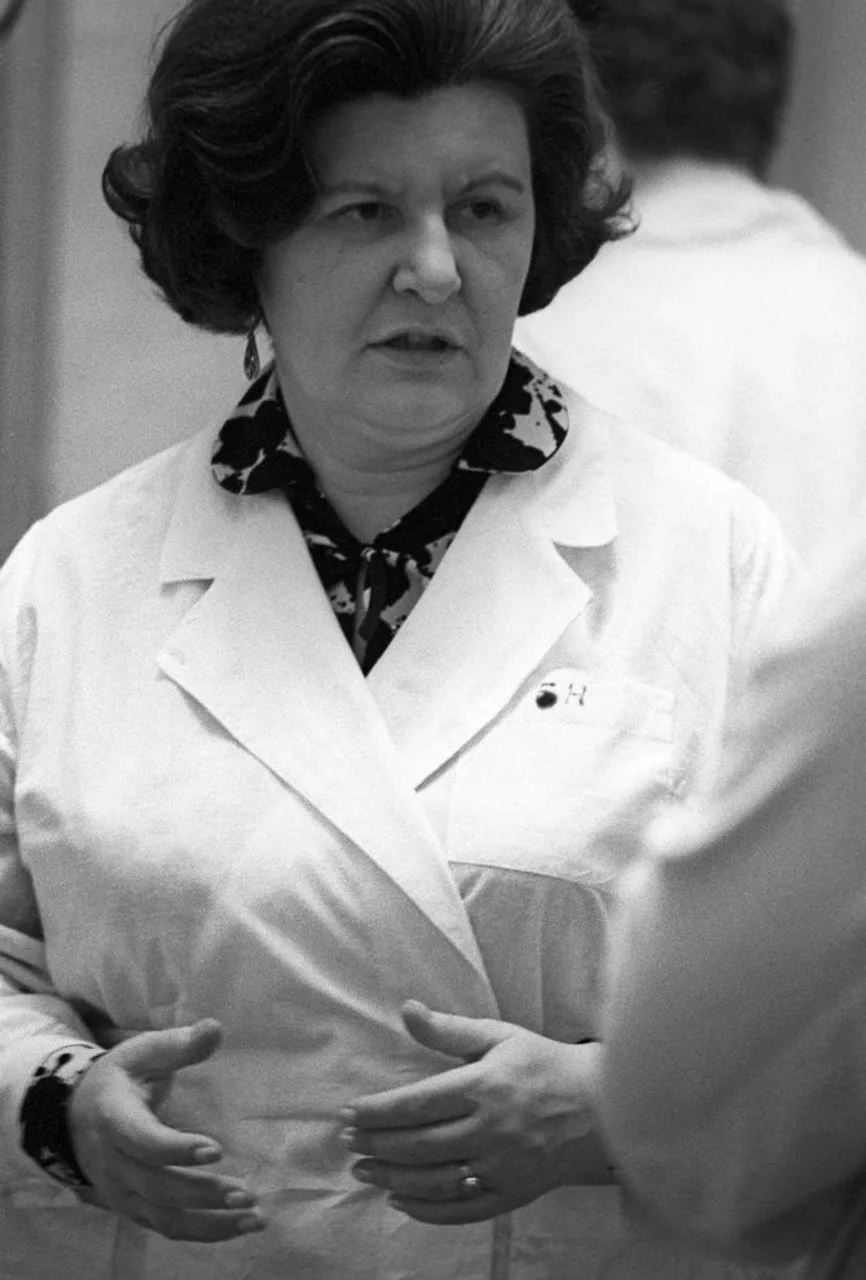 Žena u bijelom laboratorijskom ogrtaču tijekom razgovora