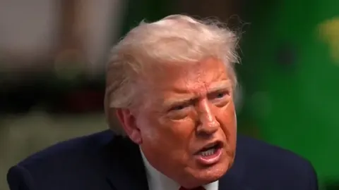 Krupni plan ljutog Donalda Trumpa koji govori u tamnom odelu