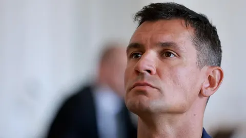 Portret Dejana Lovrena u krupnom planu s ozbiljnim izrazom lica