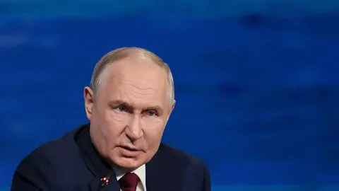 Portret Vladimira Putina u tamnom odjeću s ozbiljnim izrazom lica