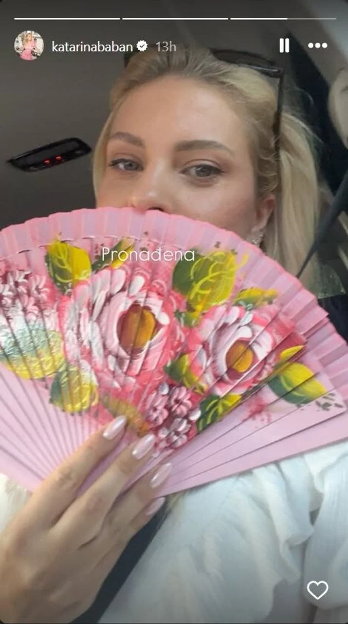 Katarina Baban drži roza lepezu s cvjetnim uzorkom ispred lica